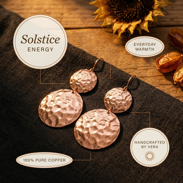 Detail shot of hammered texture on circular copper disc earrings with warm rose gold metallic tone