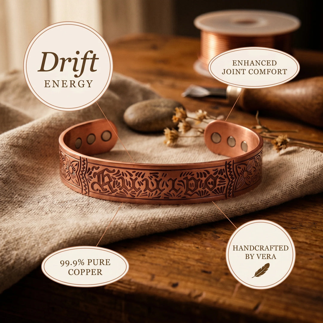 Engraved copper cuff bracelet displayed on linen showing warm metallic finish and gothic lettering detail