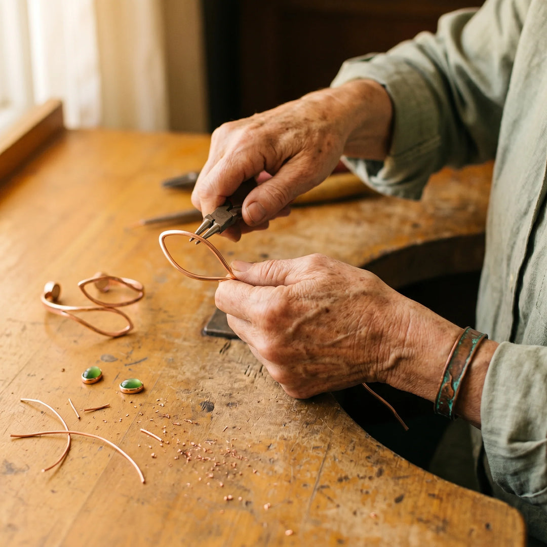 Handcrafted copper bracelet featuring two green stones in sculptural wire frames