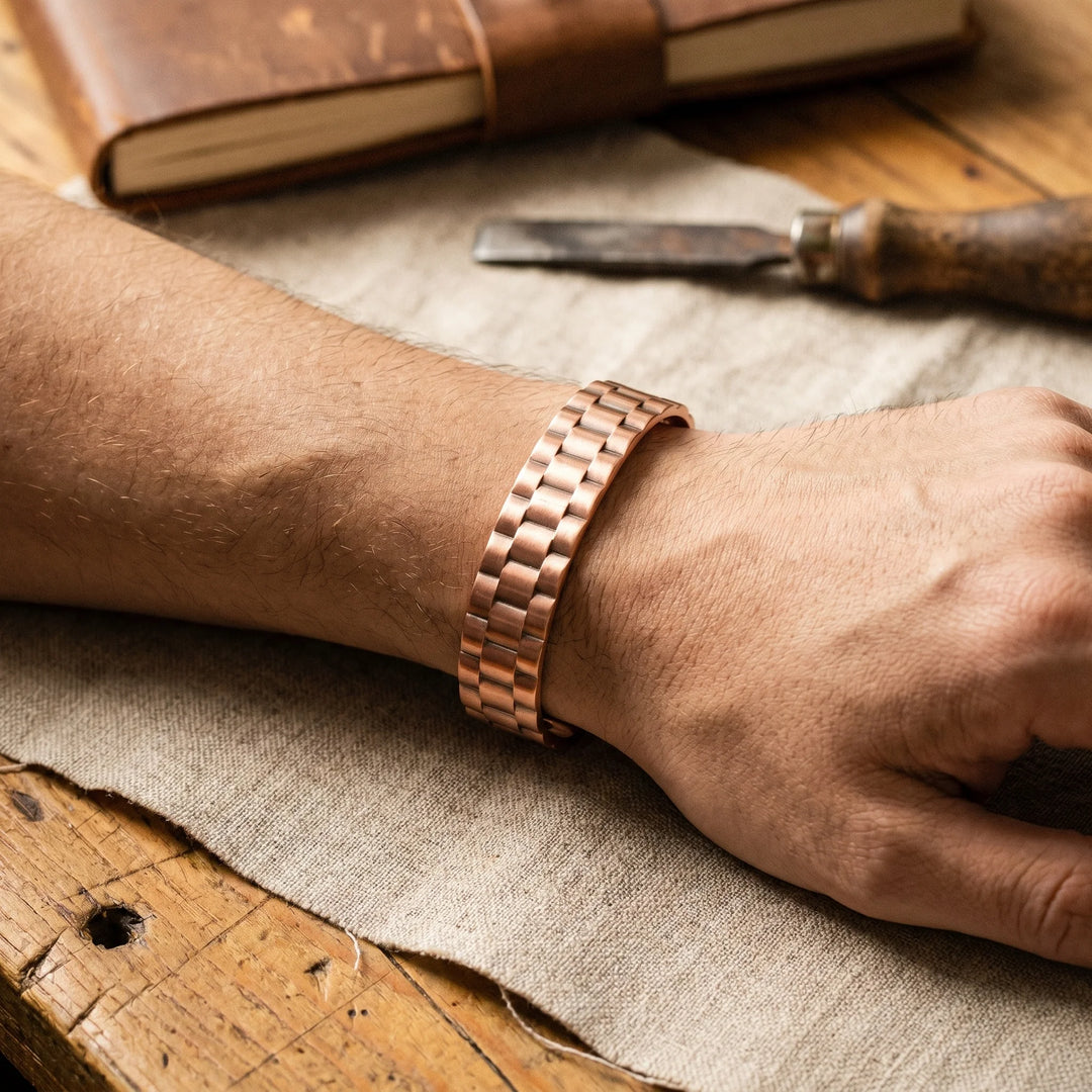 Wide copper cuff bracelet showing adjustable open-back design and embossed pattern detail