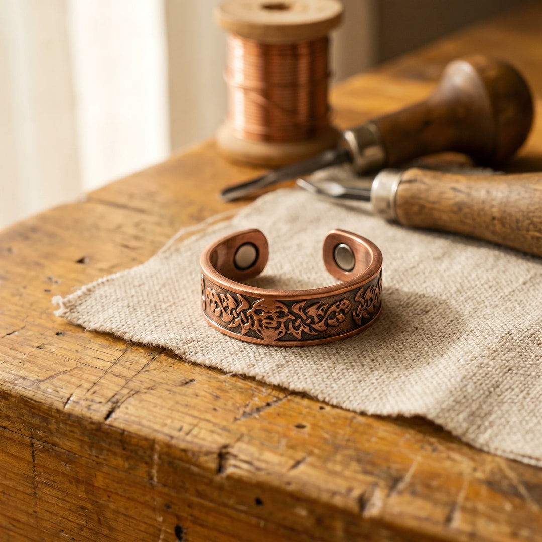 Women's copper cuff ring with hand-engraved floral pattern displayed on rustic wooden surface