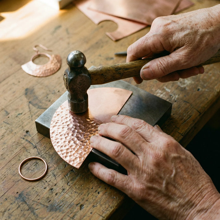 Artisan copper earrings featuring hammered texture and geometric crescent shape with hook fastening