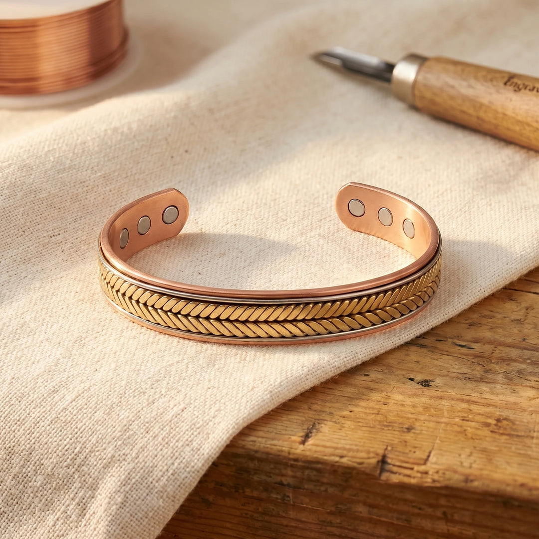 Copper cuff bracelet with hand-pressed chevron pattern and open adjustable design on linen surface