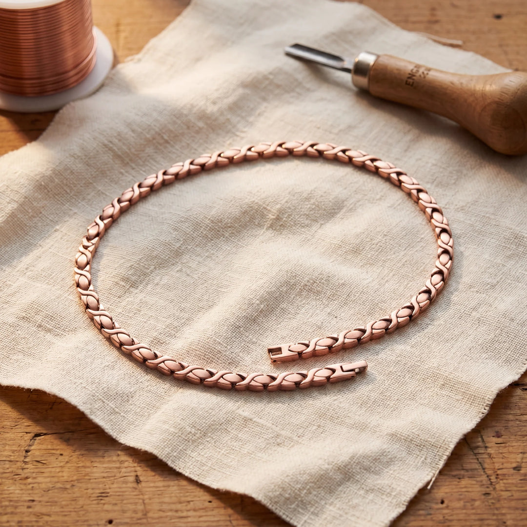 Close-up of handcrafted copper chain necklace showing individual X-shaped link construction and warm metallic finish