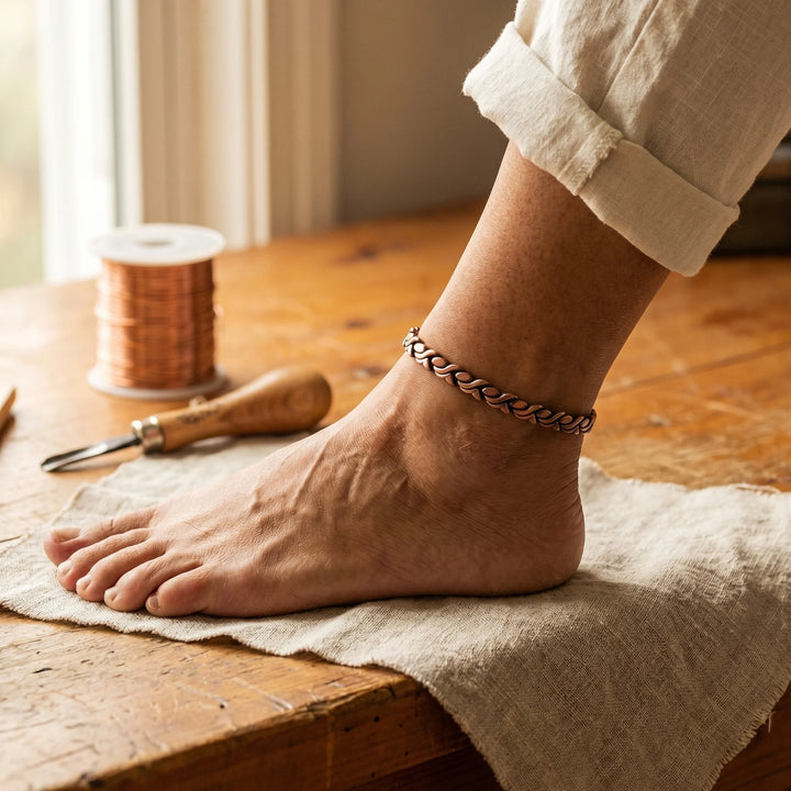Women's copper chain anklet worn around ankle with interlocking links and warm metallic finish
