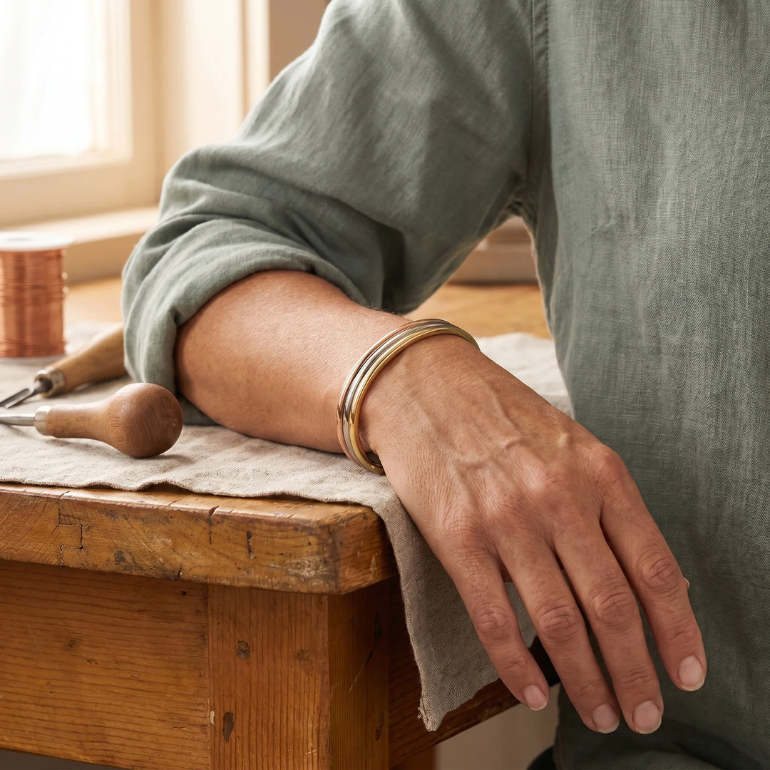 Close-up of copper cuff bracelet showing three polished metal bands and interior magnets