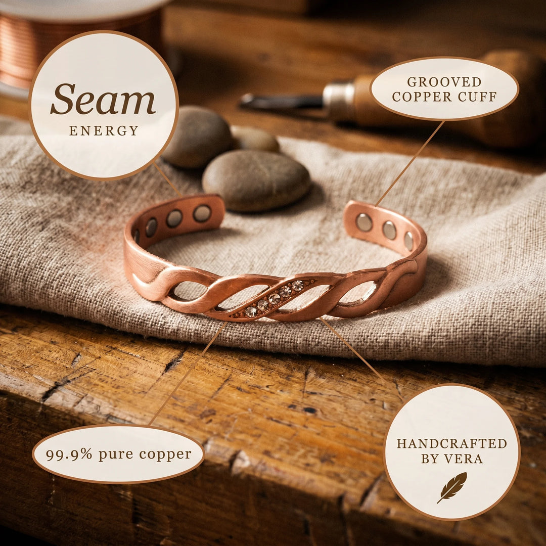 Copper cuff bracelet with warm metallic tone and decorative braided pattern on textured background