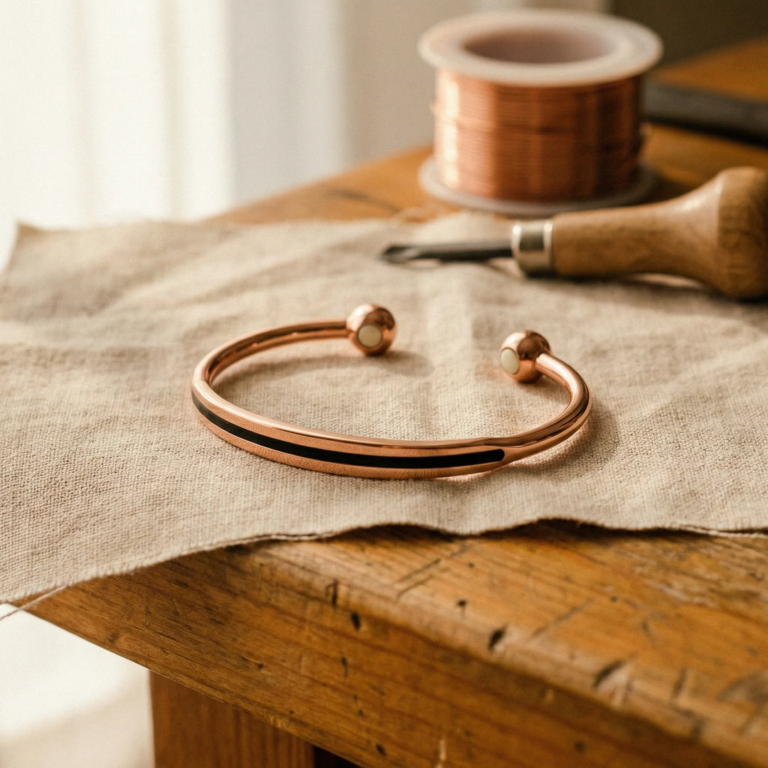 Sophie copper open cuff bracelet with polished ball terminals on linen fabric surface
