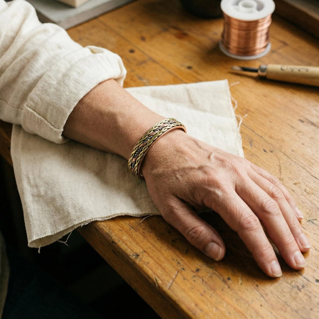 Close-up of copper cuff bracelet showing textured woven detailing and open-back design