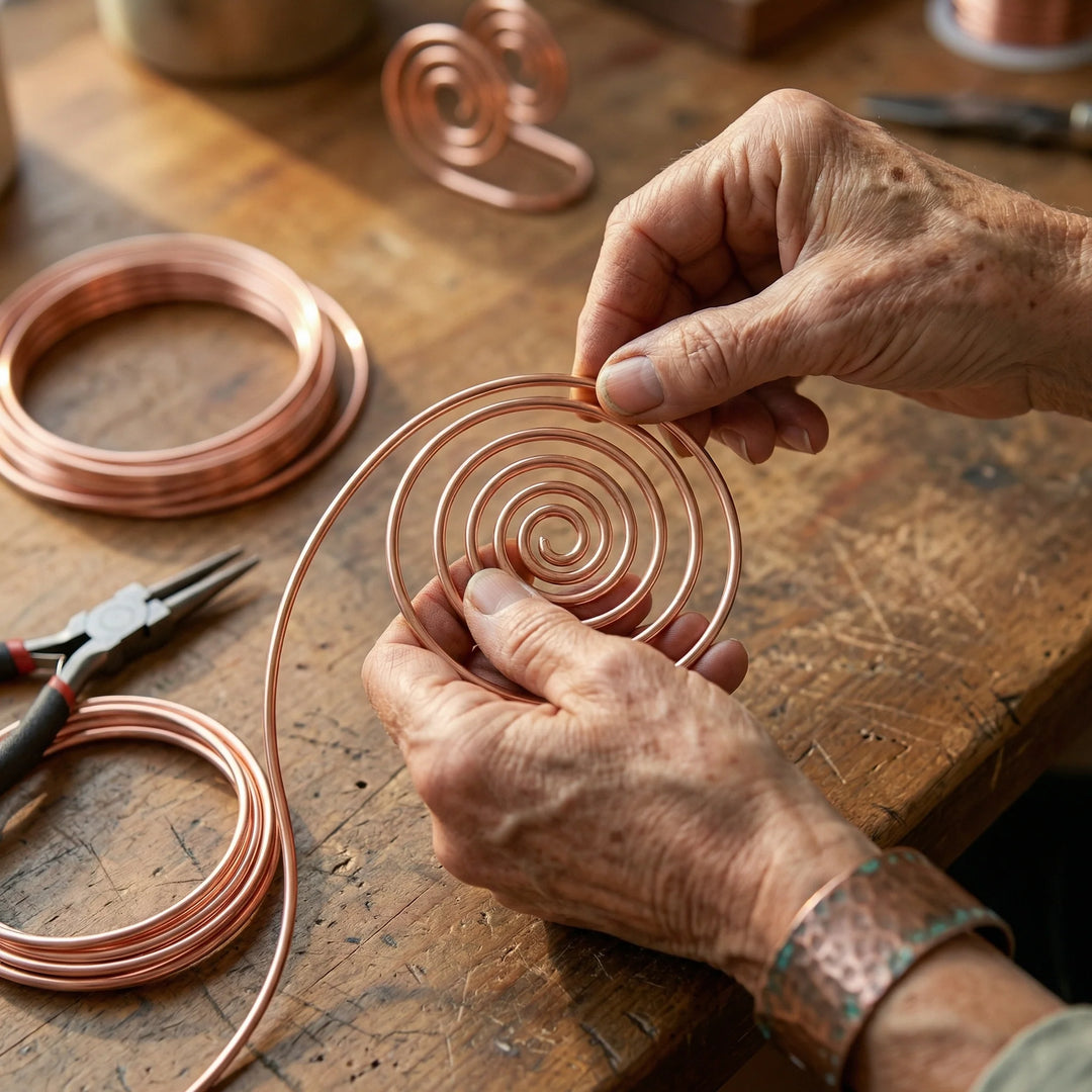 Detail of copper wire spiral hand jewellery displaying smooth finish and artisan-formed concentric rings